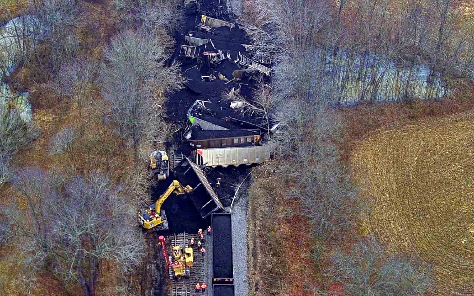 drone footage of a drain derailment with workers and equipment surrounding the scene and cleaning up the toxic waste