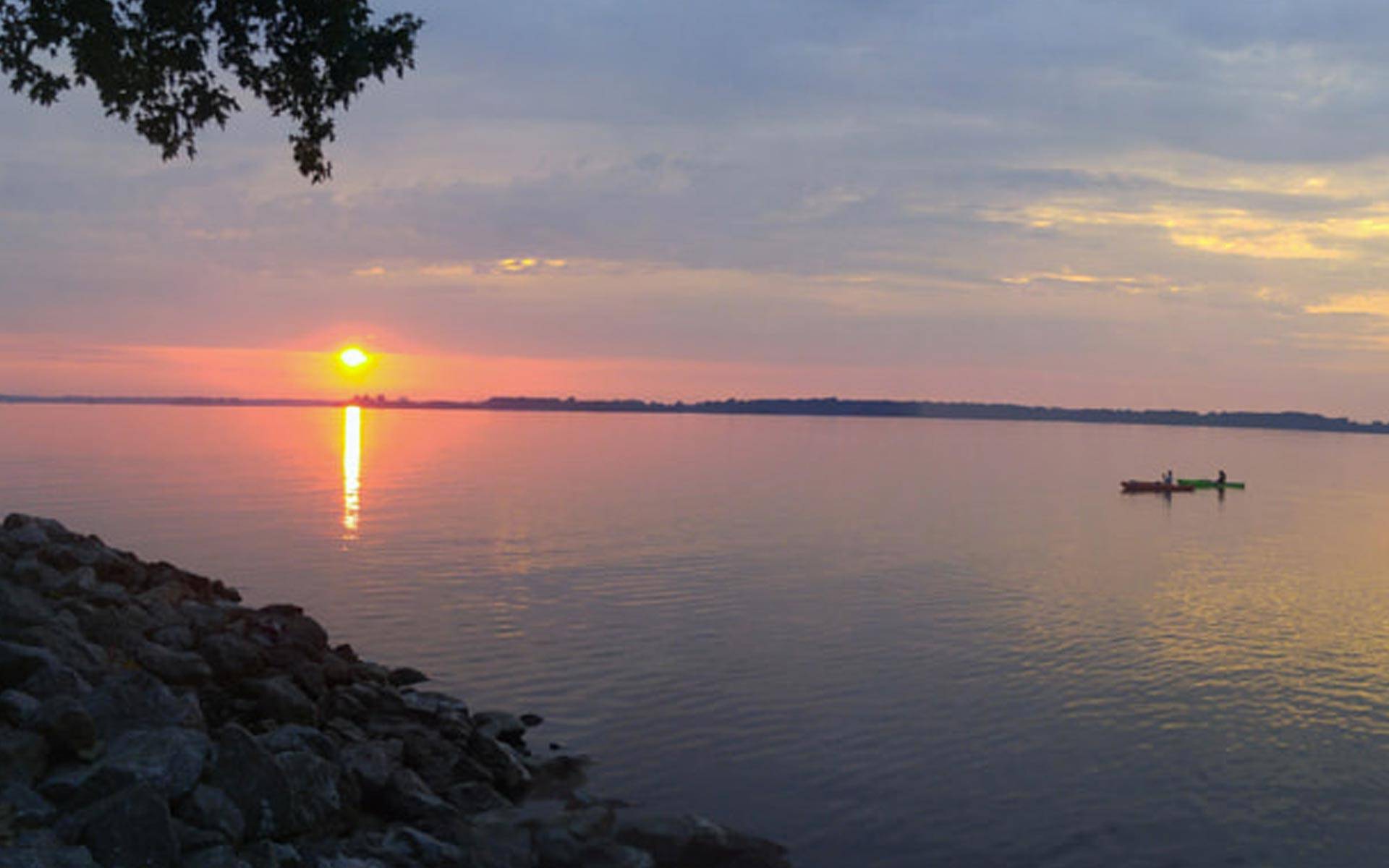 two people on rend lake illinois in their kayaks at sunset